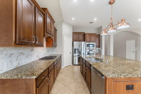 a kitchen with stainless steel appliances granite countertop a sink and stove