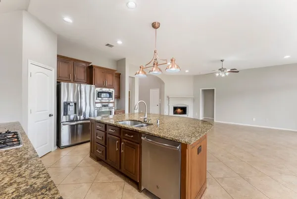 a kitchen with stainless steel appliances granite countertop a sink a stove and refrigerator
