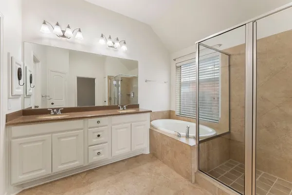 a spacious bathroom with a granite countertop tub sink and shower