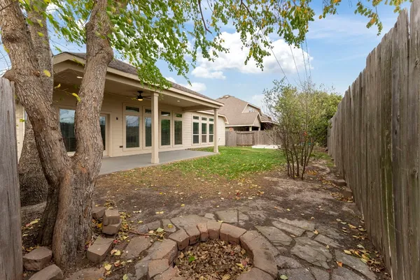 a view of a chair and table in backyard of the house