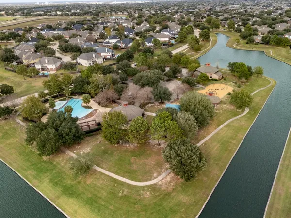 a view of a swimming pool with a yard and palm trees