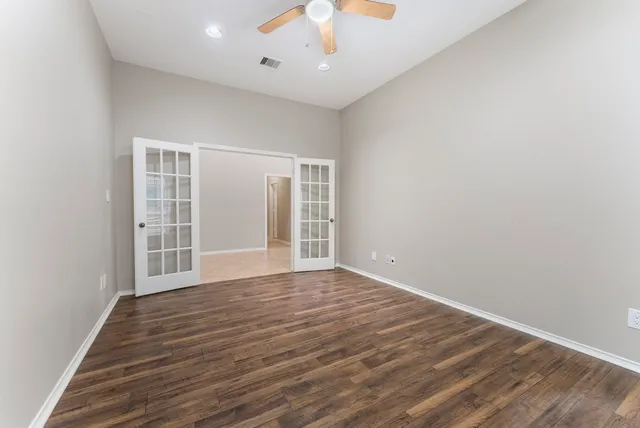 a view of a room with wooden floor chandelier and window