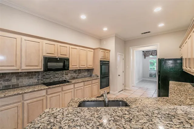 a kitchen with granite countertop a refrigerator and a sink
