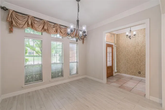 a view of a livingroom with a chandelier fan and windows
