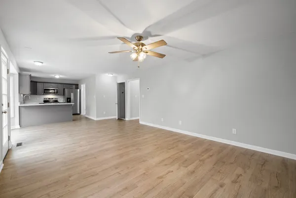 a view of an empty room with a kitchen