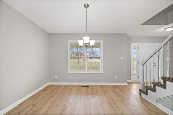 a view of a room with window wooden floor and chandelier