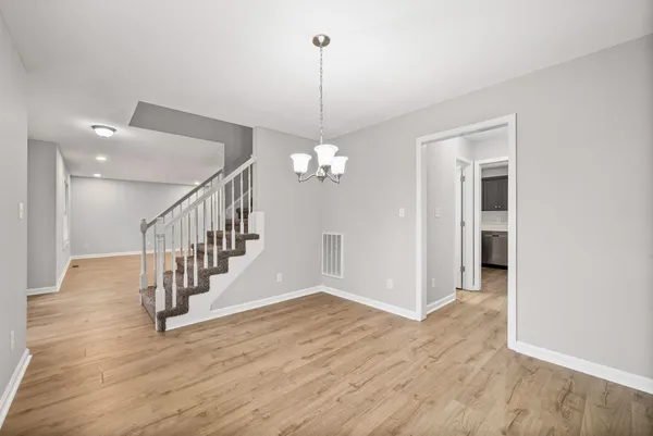 a view of a hallway with wooden floor and staircase