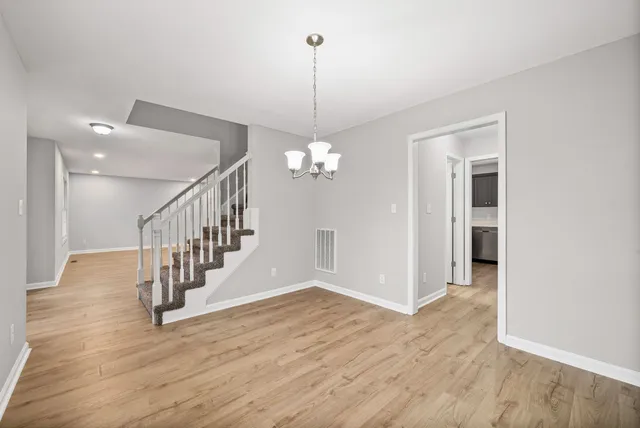 a view of a hallway with wooden floor and staircase