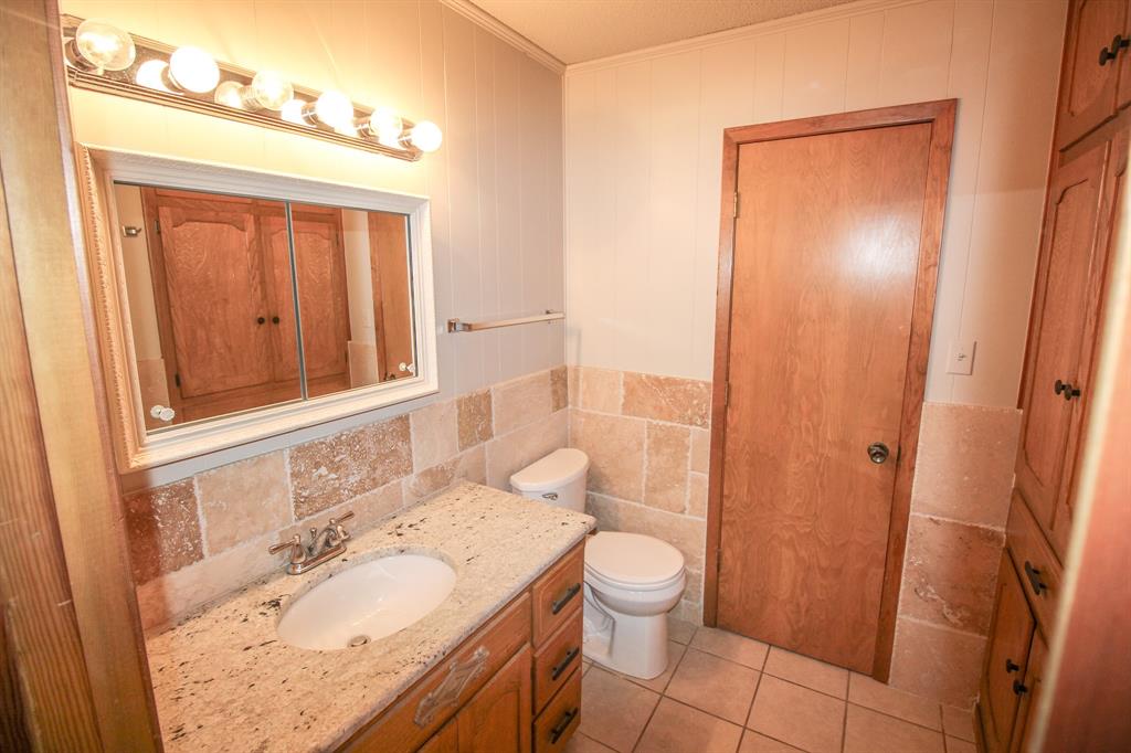 Tbd Crooked Creek Road Bowie, TX 76230 - Photo 23 of 35 a bathroom with a granite countertop sink toilet and shower