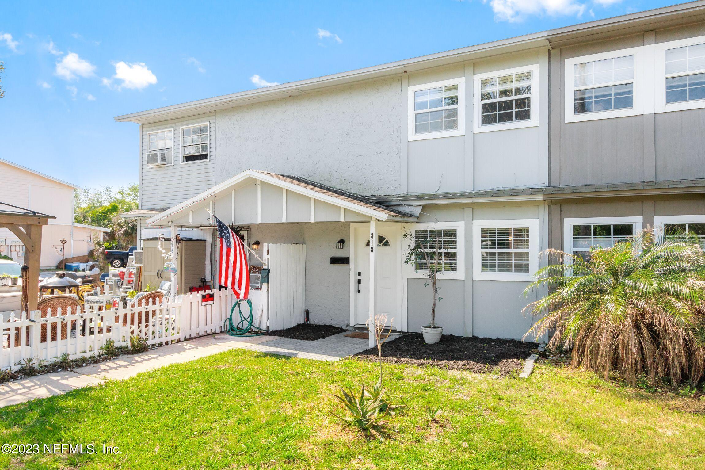 a front view of house with yard and trees in the background