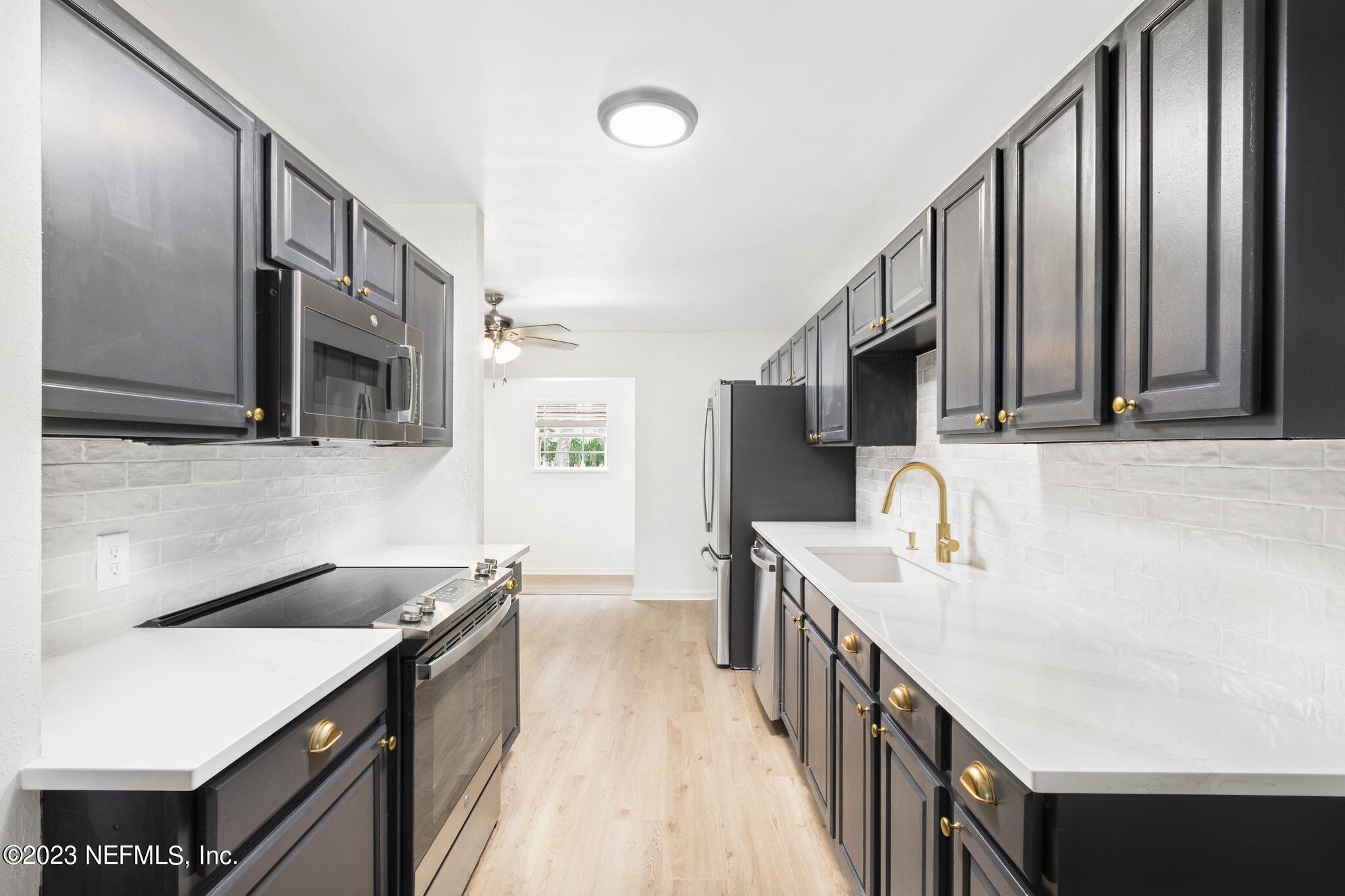 818 Cavalla Road Atlantic Beach, FL 32233 - Photo 6 of 27 a kitchen with stainless steel appliances granite countertop a sink stove and refrigerator