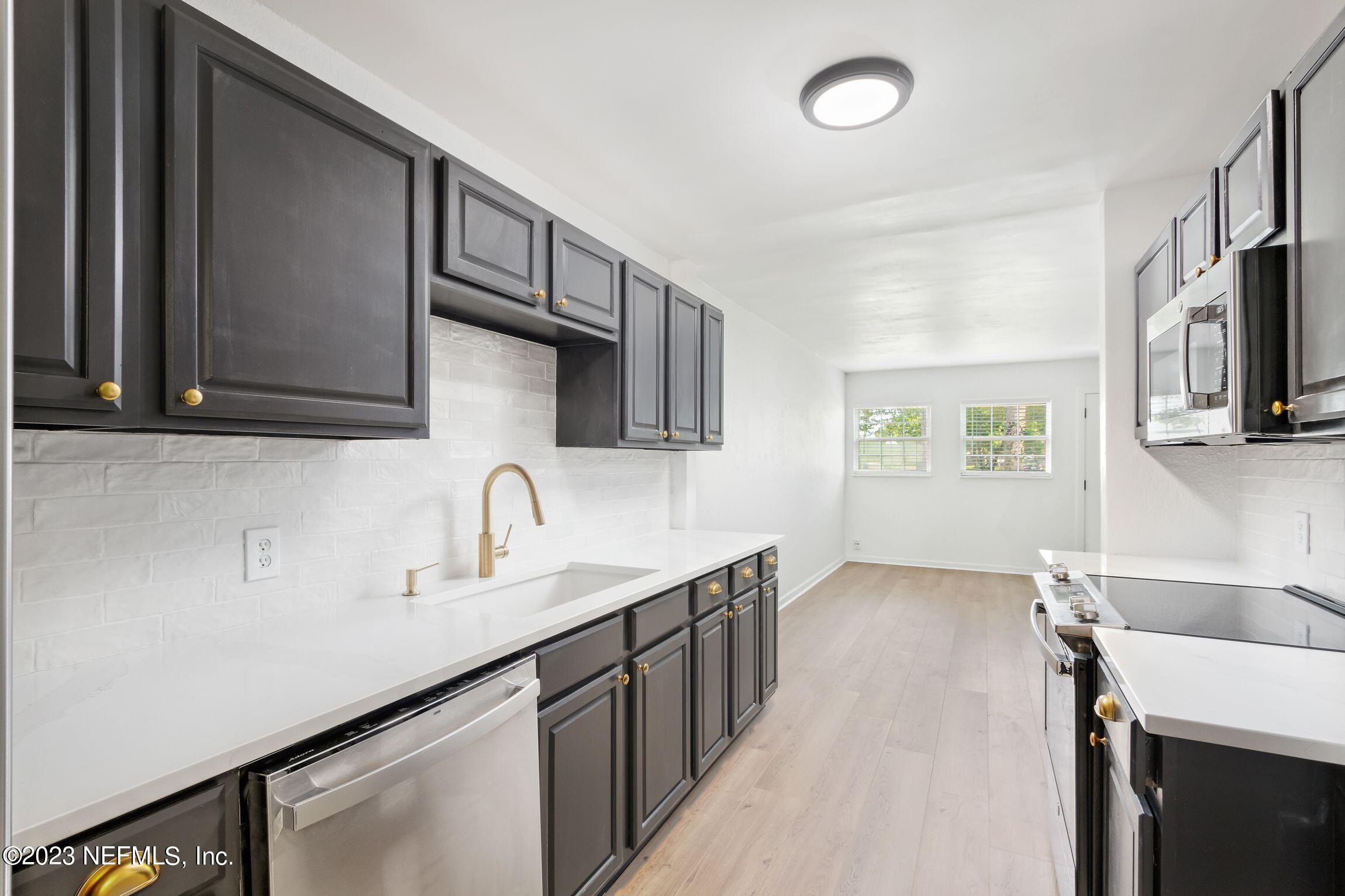 818 Cavalla Road Atlantic Beach, FL 32233 - Photo 8 of 27 a kitchen with stainless steel appliances granite countertop a sink stove and cabinets