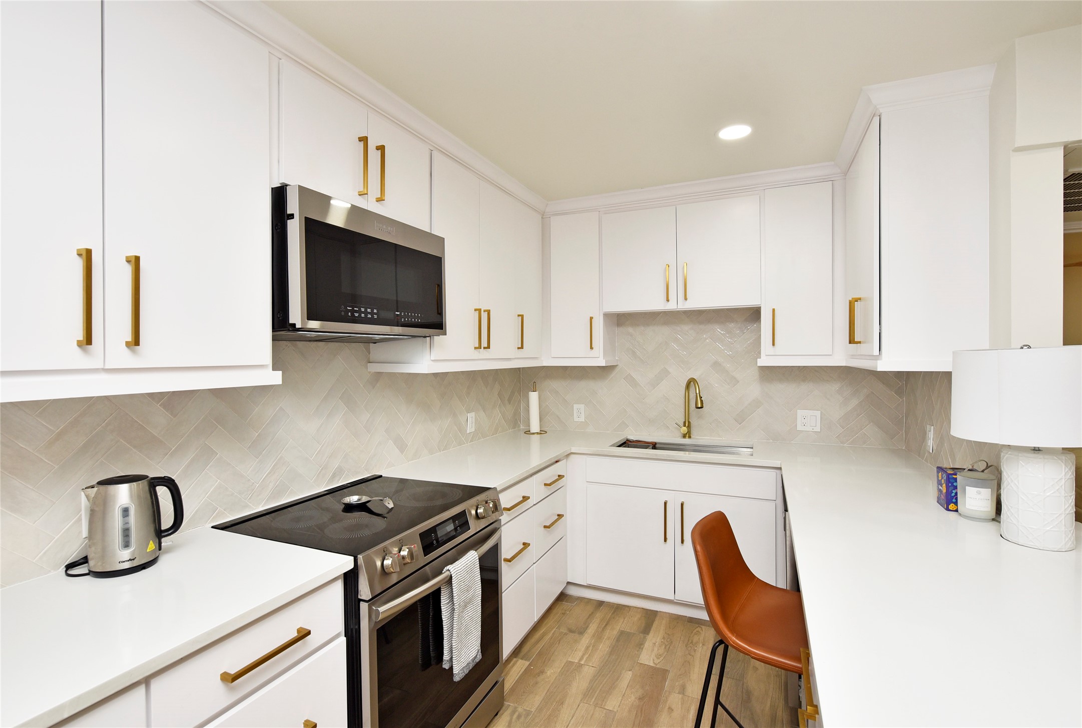 3224 Timmons Lane, Unit 112 Houston, TX 77027 - Photo 14 of 30 a kitchen with stainless steel appliances granite countertop a sink stove and microwave