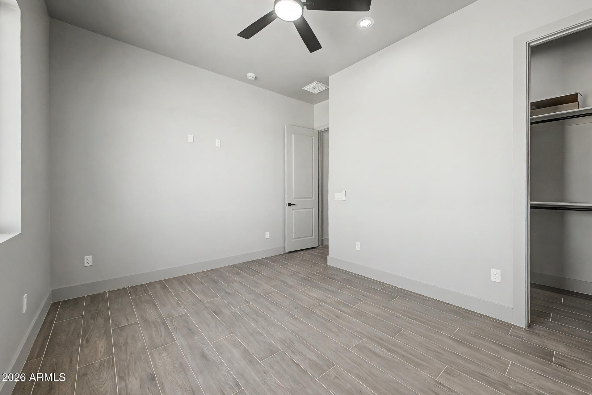 40461 West Robles Road Stanfield, AZ 85172 - Photo 40 of 54 an empty room with a ceiling fan and wooden floor