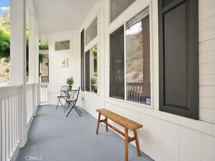 a porch with a bench and glass door