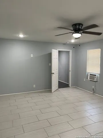 an empty room with fan and windows