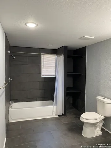 a bathroom with a toilet and a shower