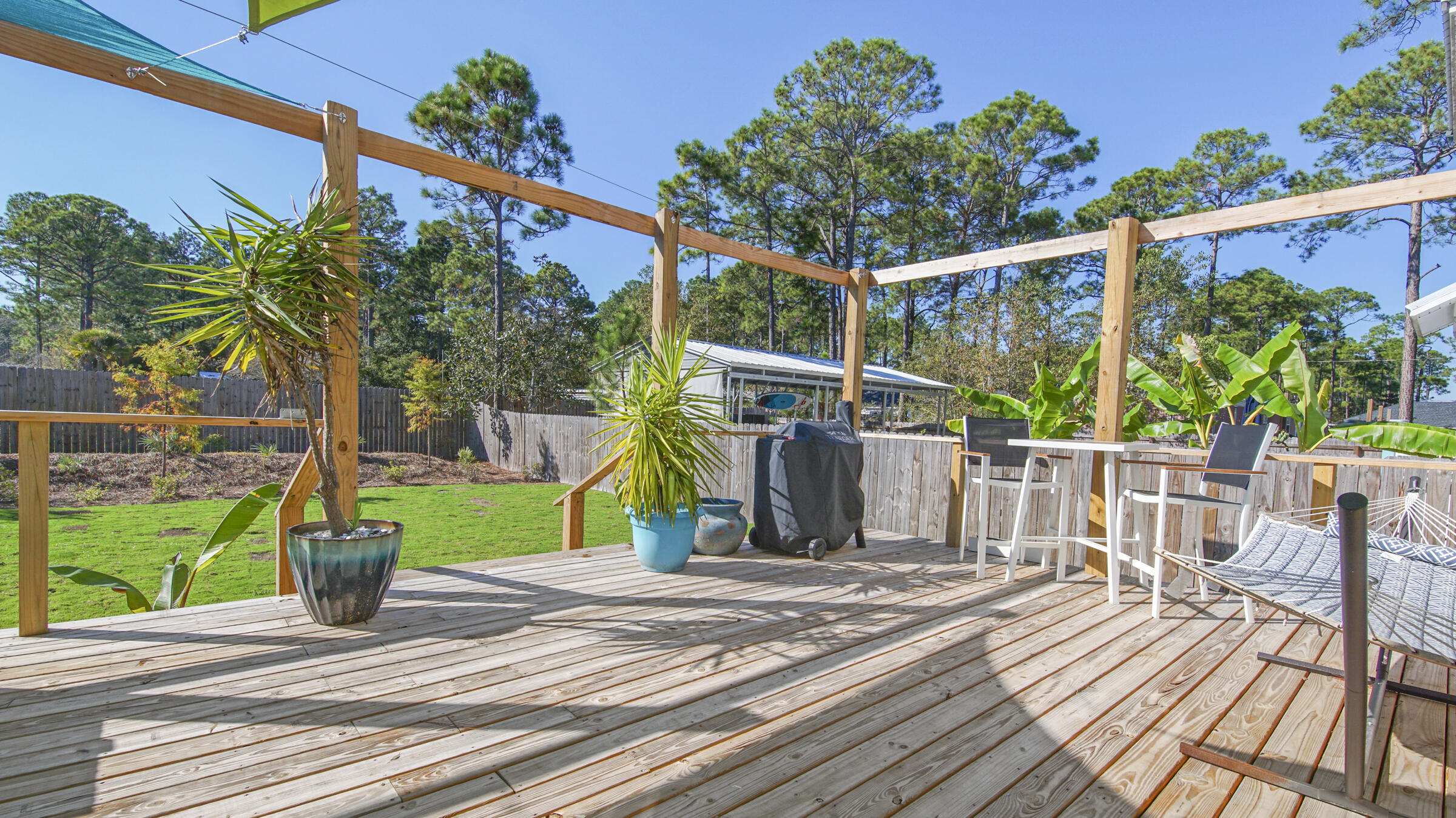 275 Indian Woman Road Santa Rosa Beach, FL 32459 - Photo 21 of 43 a view of a deck with a table and chairs with wooden floor and fence