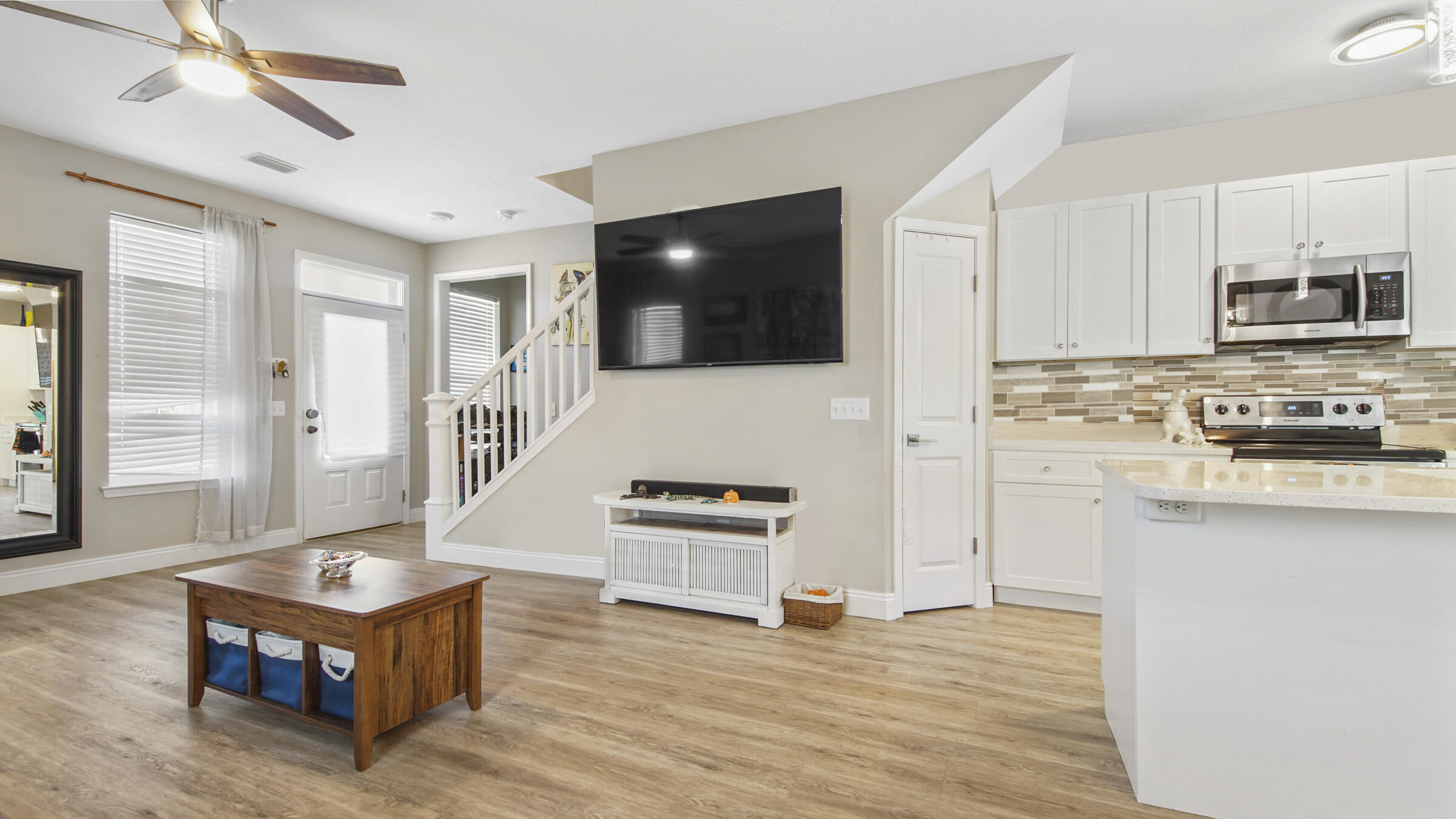 275 Indian Woman Road Santa Rosa Beach, FL 32459 - Photo 3 of 43 a living room with stainless steel appliances kitchen island granite countertop a stove a sink dishwasher and a microwave oven with wooden floor