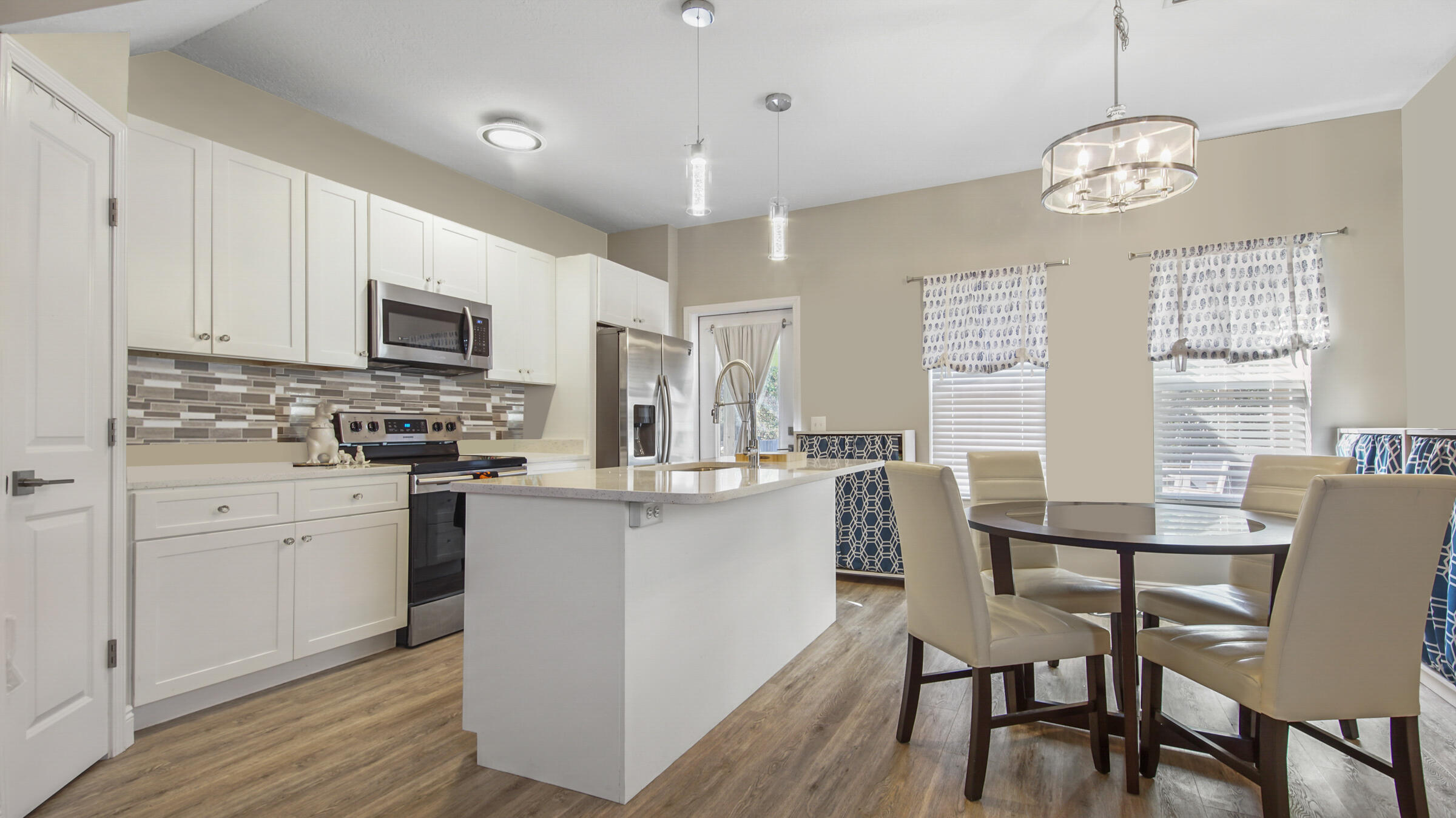 275 Indian Woman Road Santa Rosa Beach, FL 32459 - Photo 6 of 43 a kitchen with stainless steel appliances granite countertop a stove top oven a refrigerator cabinets and a dining table with wooden floor