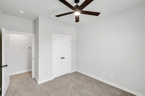 an empty room with a ceiling fan and a window
