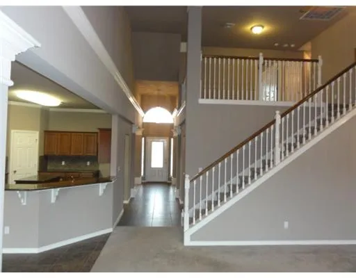 a view of staircase and kitchen with wooden floor
