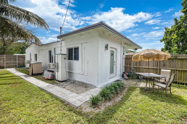 a backyard of a house with table and chairs