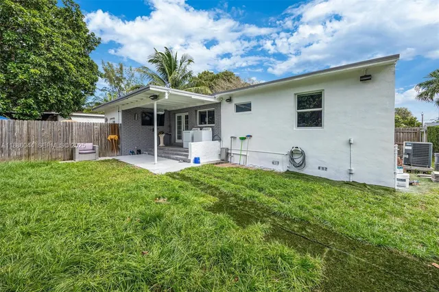 a view of a house with backyard and a tree