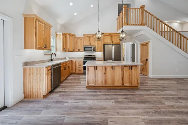 a kitchen with stainless steel appliances granite countertop a sink stove and cabinets