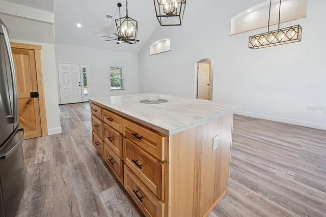 a view of a hallway with wooden floor and a bathroom