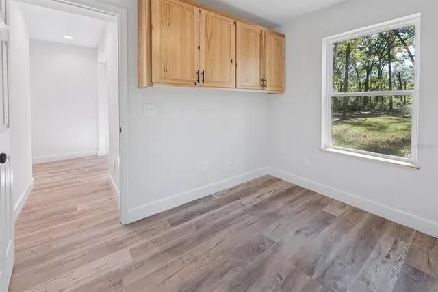 a view of empty room with wooden floor