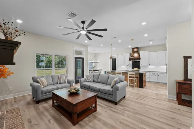 a living room with furniture a fireplace and a chandelier