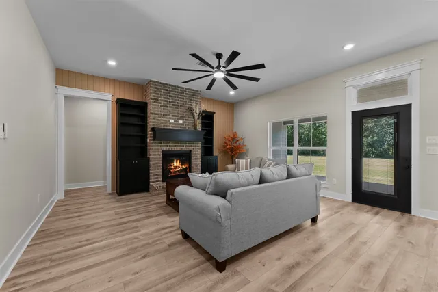 a kitchen with kitchen island granite countertop a stove a sink a refrigerator and blue cabinets with wooden floor