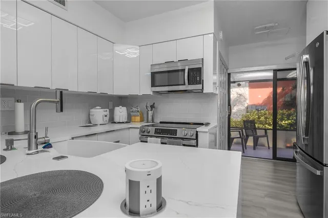 a kitchen with stainless steel appliances a sink a stove top oven a counter space and cabinets