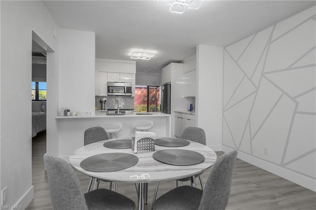 201 South Collier Boulevard, Unit 3102 Marco Island, FL 34145 - Photo 14 of 35 a dining room with furniture and wooden floor