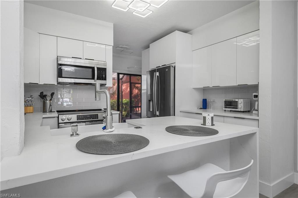 201 South Collier Boulevard, Unit 3102 Marco Island, FL 34145 - Photo 16 of 35 a kitchen with a sink stove and microwave