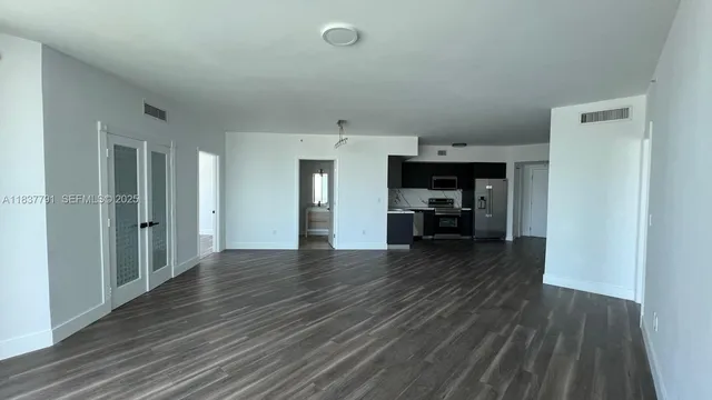 a view of empty room with wooden floor