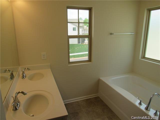 521 Common Raven Court Fort Mill, SC 29715 - Photo 14 of 25 a bathroom with a tub sink and window