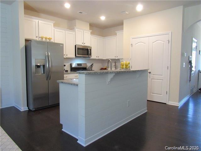 521 Common Raven Court Fort Mill, SC 29715 - Photo 7 of 25 a kitchen with stainless steel appliances a refrigerator a sink a stove a microwave and wooden floor