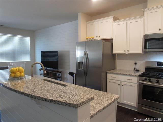 521 Common Raven Court Fort Mill, SC 29715 - Photo 8 of 25 a kitchen with granite countertop a sink a stove and refrigerator