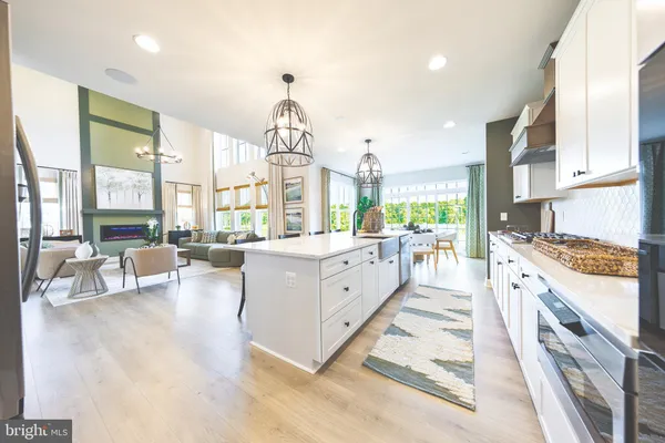 a large kitchen with kitchen island a large window a sink and stainless steel appliances