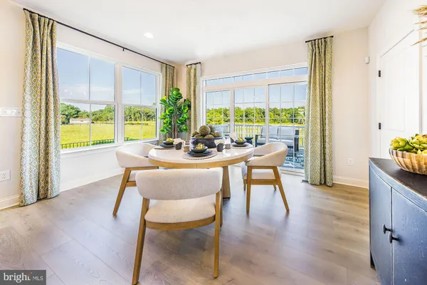 a dining room with furniture window and wooden floor
