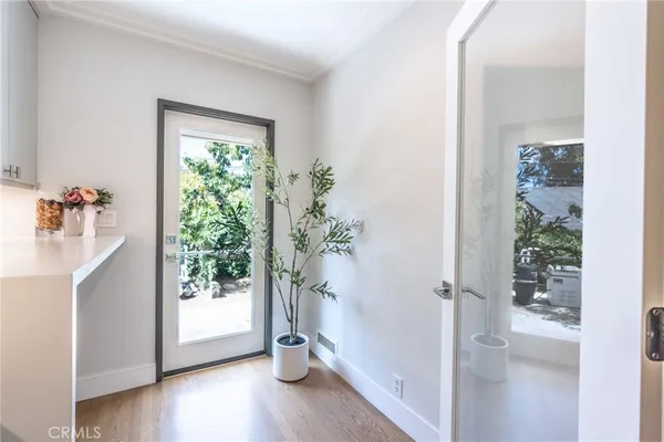 a view of a hallway with wooden floor and a bathroom