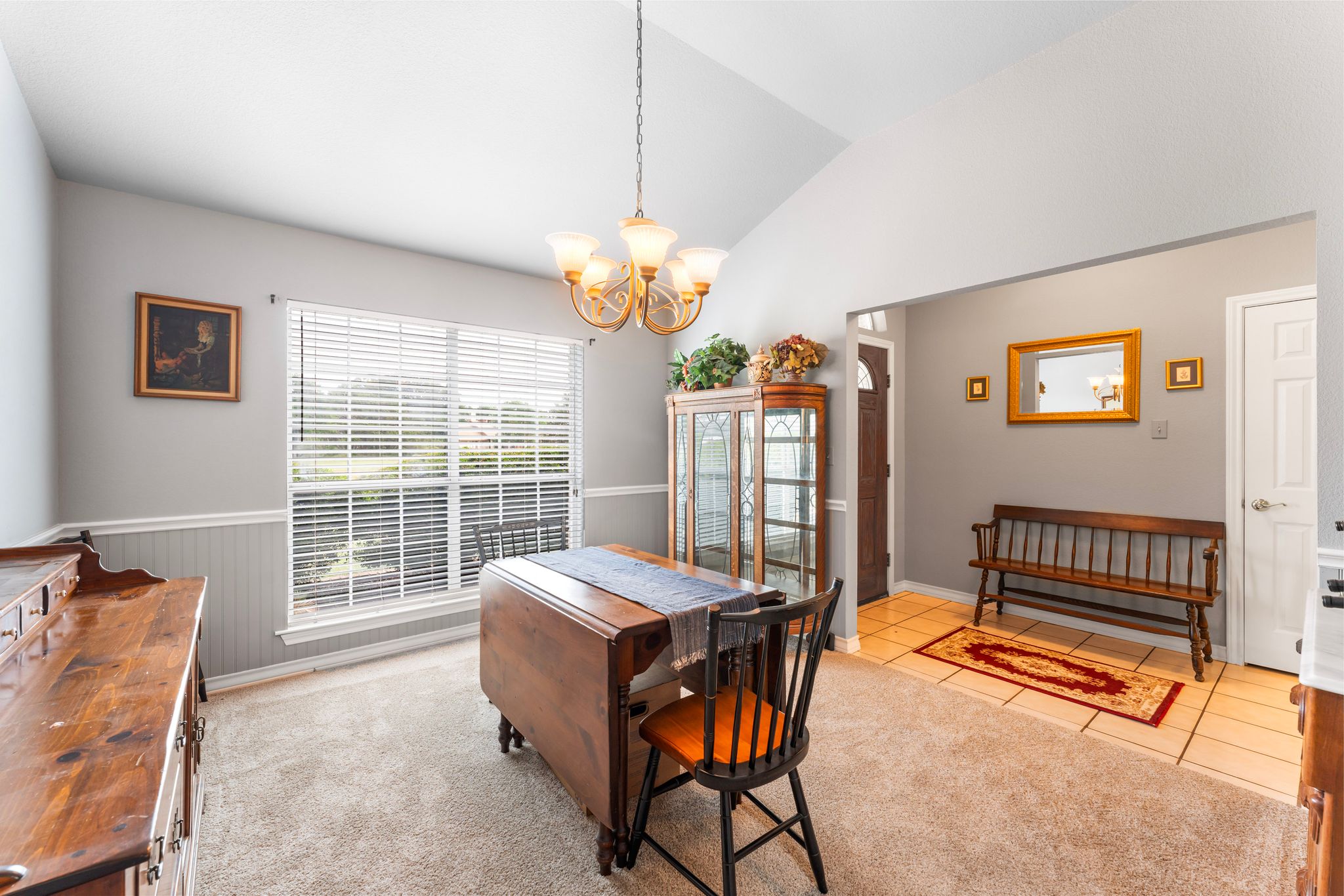 221 Breakaway Road Cedar Park, TX 78613 - Photo 21 of 39 Tiled dining room featuring a chandelier, vaulted ceiling, and wainscoting