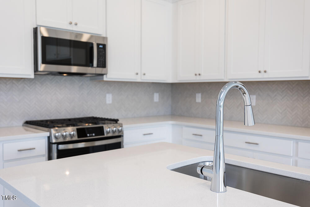 161 Charlie Smith Road Angier, NC 27501 - Photo 3 of 57 a kitchen with a stove and white cabinets