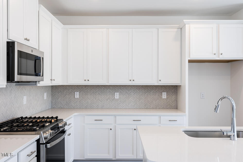 161 Charlie Smith Road Angier, NC 27501 - Photo 6 of 57 a kitchen with granite countertop white cabinets and stainless steel appliances