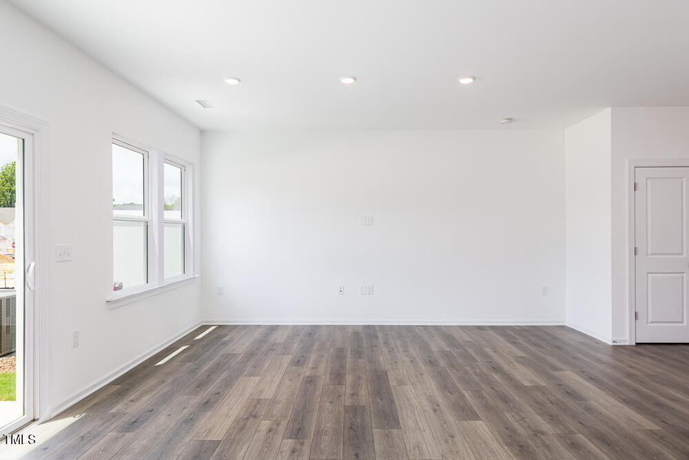 161 Charlie Smith Road Angier, NC 27501 - Photo 9 of 57 an empty room with wooden floor and windows