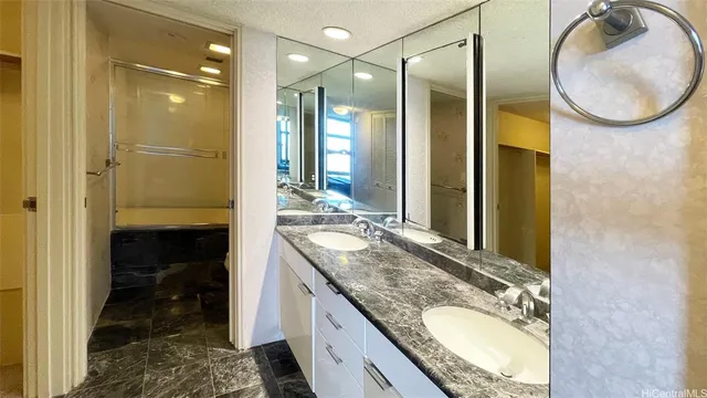 a en suite bathroom with a granite countertop sink and a mirror