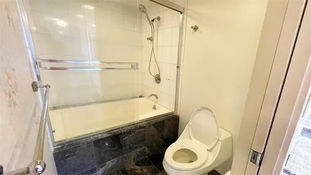 a bathroom with a toilet and a shower