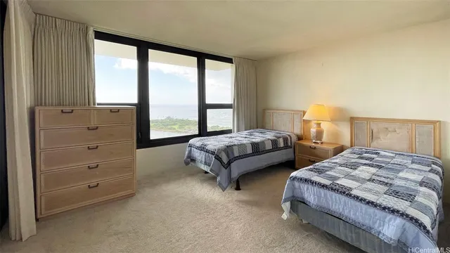 a spacious bedroom with two beds and large window